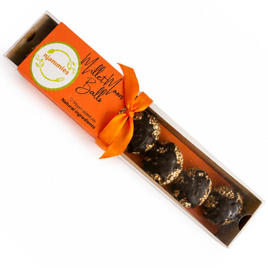 Njammies Millet Moon Balls in an orange gift-style box with chocolate-drizzled millet bites.