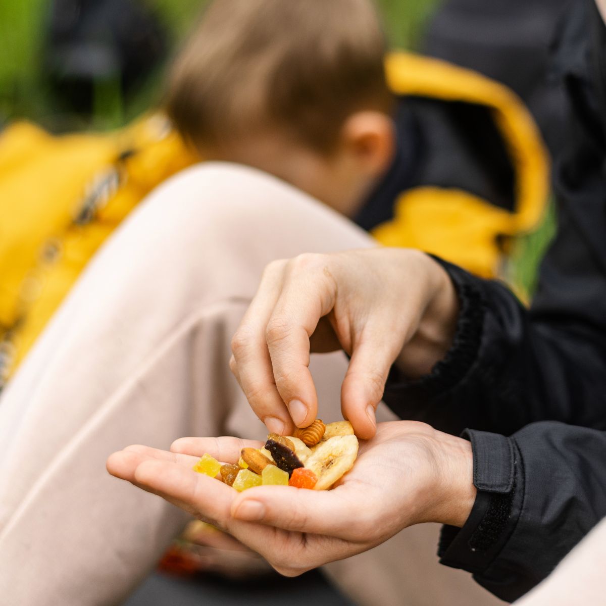 Woman enjoying a Njammies Fruit Pocket snack outdoors.