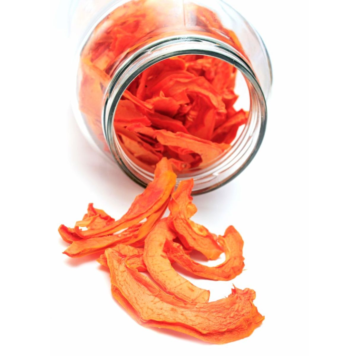Naturally dried papino fruit pieces displayed in and around a glass jar.