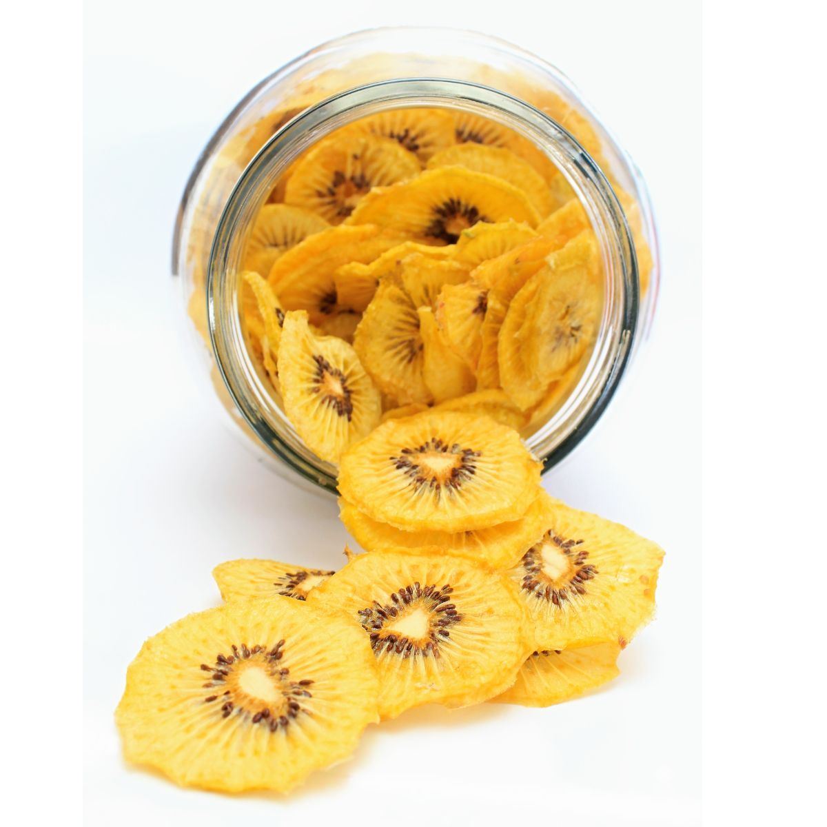 Naturally dried kiwi fruit pieces displayed in and around a glass jar.