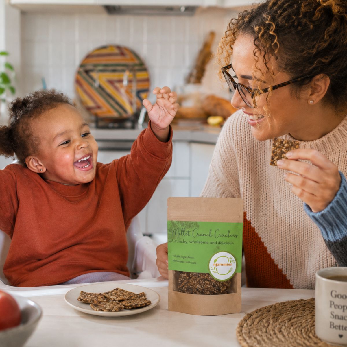 Child and adult enjoying Njammies Crackers together at the table.