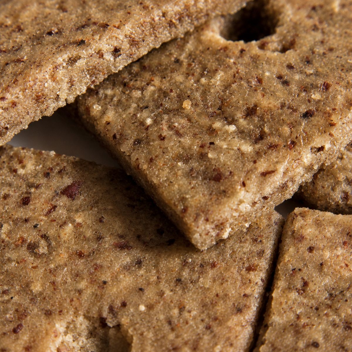 Close-up of crisp Njammies Millet Crunch Crackers with seeds and herbs.