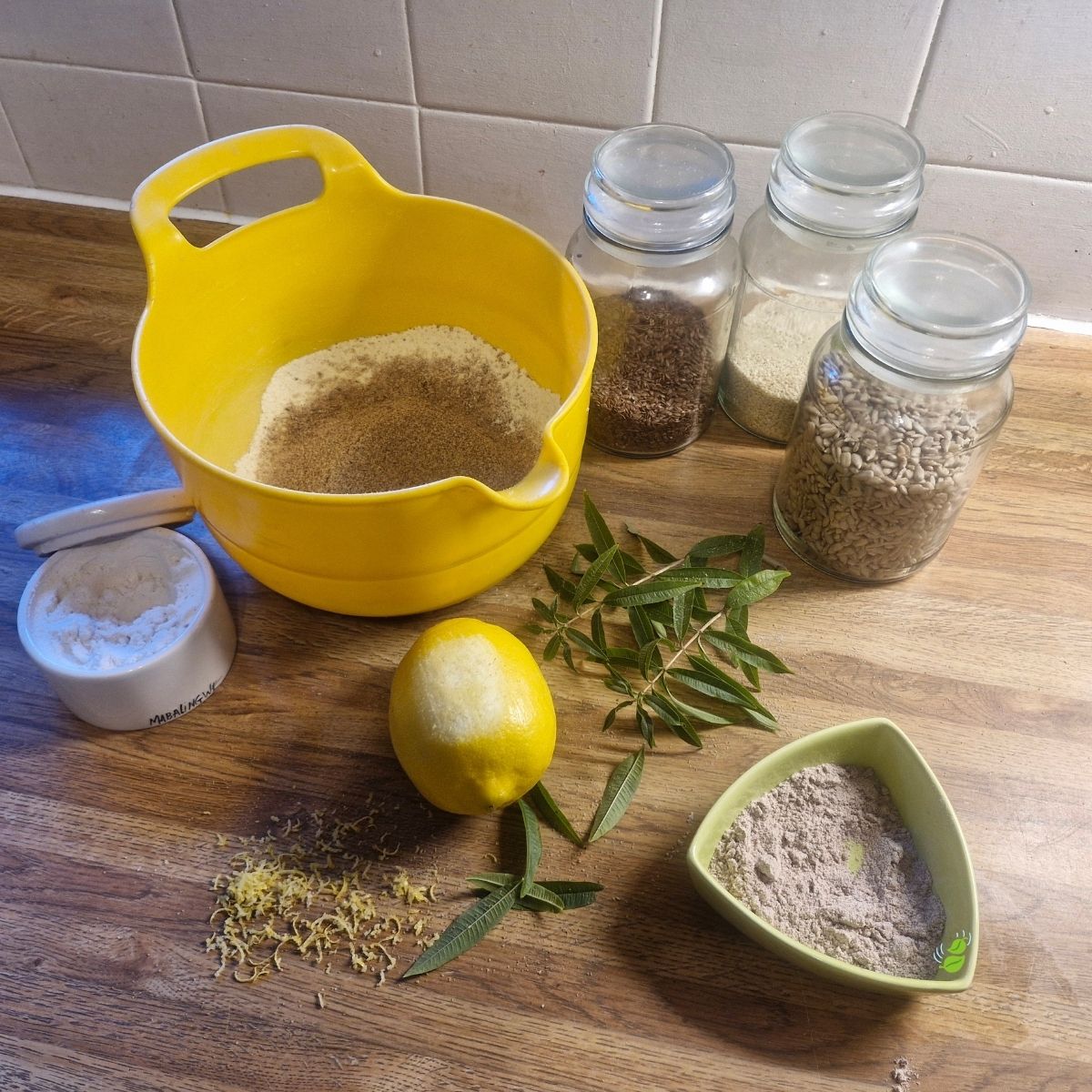 Ingredients used to make Njammies Millet Crunch Crackers, including grains, seeds, herbs and lemon.