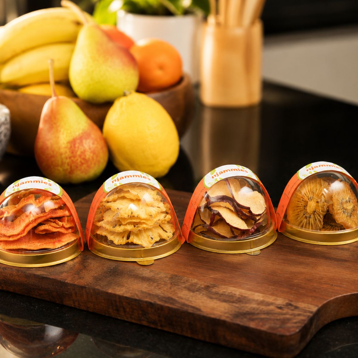 Njammies Fruit Treasure range showing individual dried fruit varieties in clear dome containers.